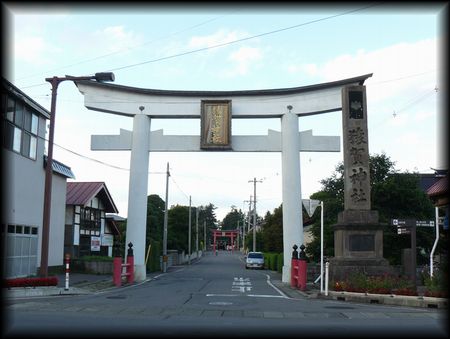 猿賀神社参道正面に設けられた真っ白な大鳥居と石造社号標